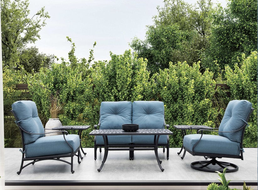 Blue padded cusions on a Mayfair Club Seating Patio Set on a patio with lush landscaping