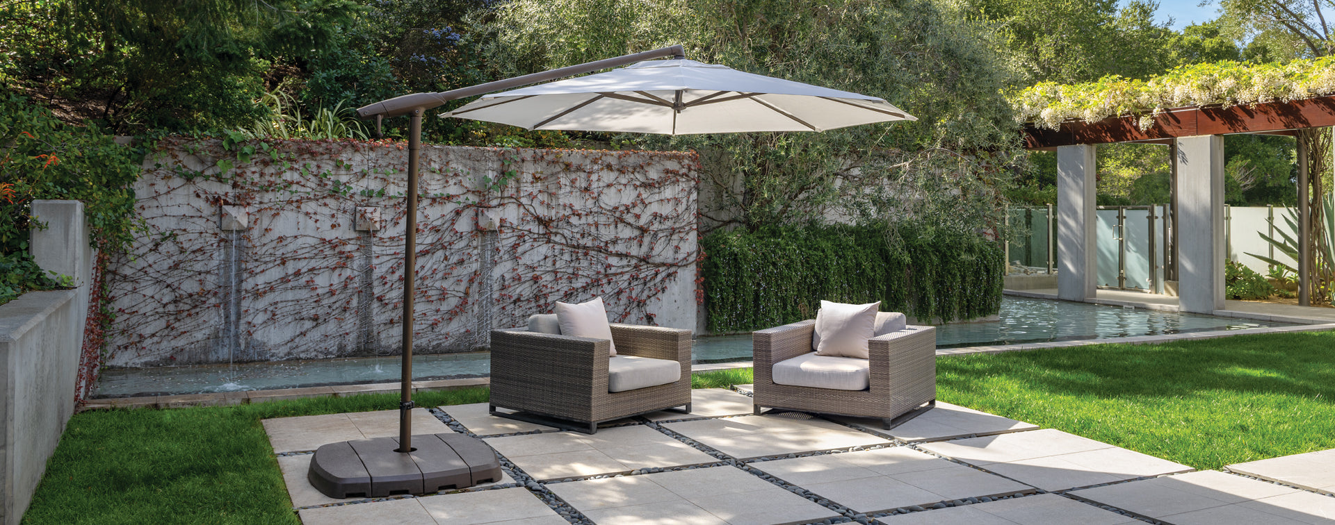 Photo of a large umbrella over 2 patio chairs.